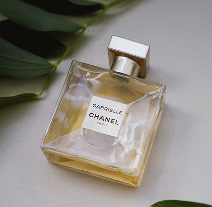 perfume with a white background and leaves
